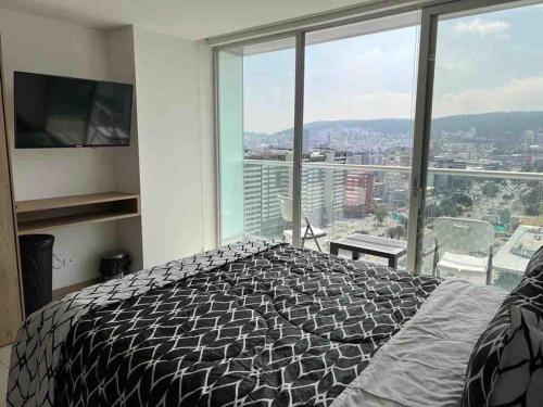 a bedroom with a bed and a large window at Lovely View Studio Building Heated Pool Gym Turco WIFI in Quito