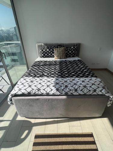 a large bed in a room with a window at Lovely View Studio Building Heated Pool Gym Turco WIFI in Quito