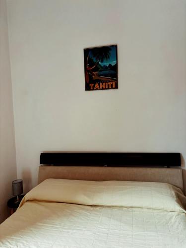 una camera da letto con un letto e un quadro sul muro di Station Comfort House a Pagani