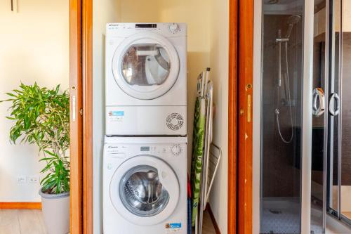 a washing machine and a washer and dryer in a room at [Cotton Flower} Attico 15 minuti da Malpensa MXP in Busto Arsizio