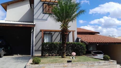 a palm tree in front of a house at Casa em condomínio em Taubaté in Taubaté