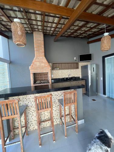 a kitchen with two chairs and a counter with a fireplace at Casa em condomínio em Taubaté in Taubaté