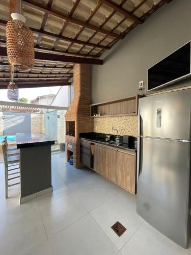 a kitchen with a stainless steel refrigerator and a counter at Casa em condomínio em Taubaté in Taubaté
