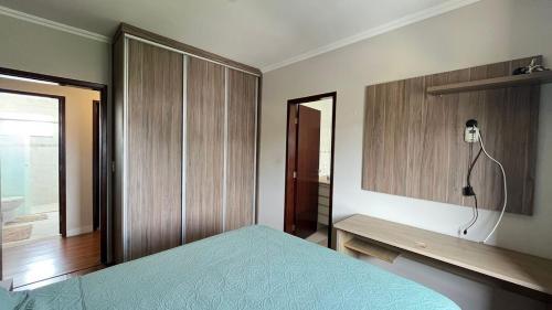a bedroom with a bed and a desk with a lamp at Casa em condomínio em Taubaté in Taubaté