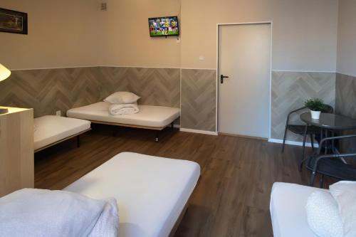 a room with two beds and a table and a door at Rynek 7 in Katowice