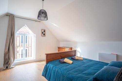 a bedroom with a blue bed and a window at Gite le palefrenier - 6 pers - 10 min Etretat in Gonneville-la-Mallet