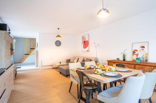 a dining room and living room with a table and chairs at Gite le palefrenier - 6 pers - 10 min Etretat in Gonneville-la-Mallet