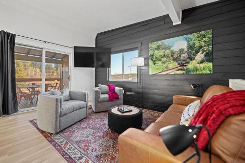 a living room with a couch and chairs and a tv at Fireside Haven - Hot Tub & Downtown Walkable in Custer