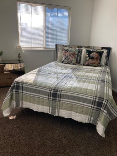 une chambre avec un lit avec une couverture à carreaux dans l'établissement Cozy & Stylish, à Aurora
