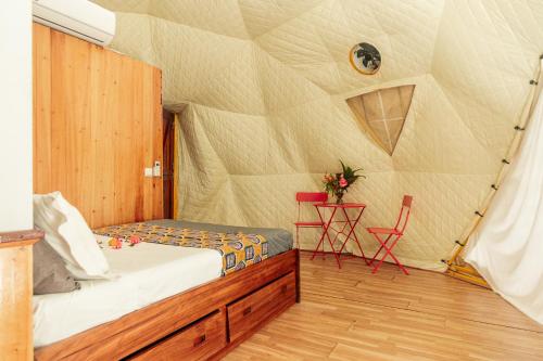 a bedroom with a bed in a tent at Eden Valley Ecolodge and Farming in Madalena