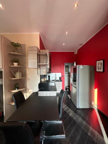 cocina con mesa negra y pared roja en Casa Gran Madre, en Turín
