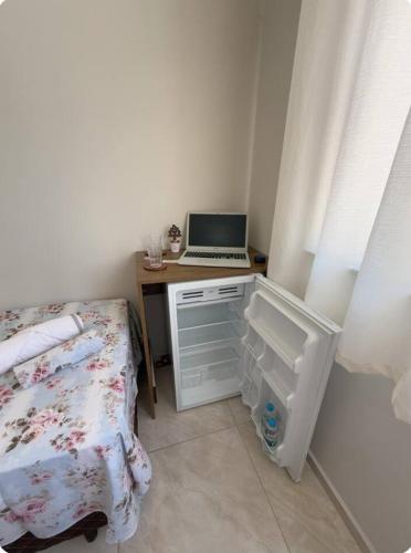a bedroom with a desk with a laptop computer on it at Suítes Nina e Malu in Santa Cruz Cabrália