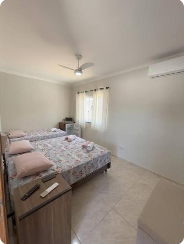 a bedroom with a bed and a table in it at Suítes Nina e Malu in Santa Cruz Cabrália