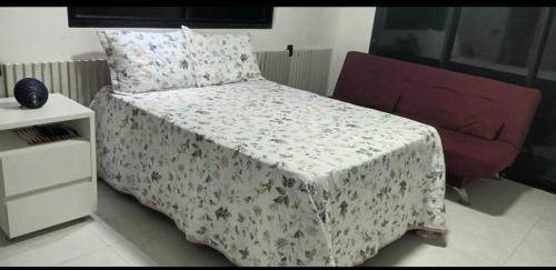 バーハ・デ・サン・ミゲウにあるCasa Nossaのベッドルーム1室(花の咲く毛布と椅子付)