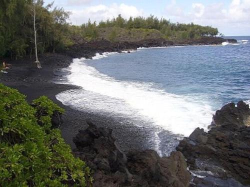 a black beach with rocks and water and trees at Nice Studio w/ AC near Kehena Beach and lava fields in Kehena