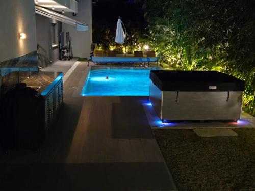 a swimming pool in a backyard at night at TG NEW Luxury Private Resort & SPA Villas - Heated Salty Swimming Pool, Outdoor Jacuzzi, Sauna, Exotic Garden in Limassol