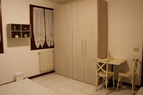 a bedroom with a desk and a table and a cupboard at Passion Horse's House FC in Vigonza