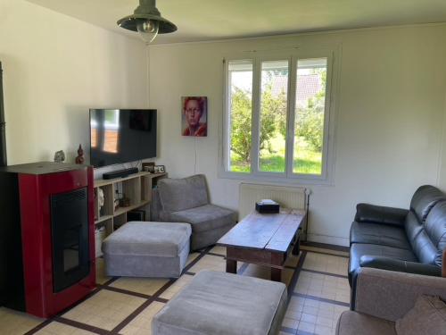 a living room with a couch and a tv at Maison de Campagne pour 6 personnes Baromesnil in Baromesnil