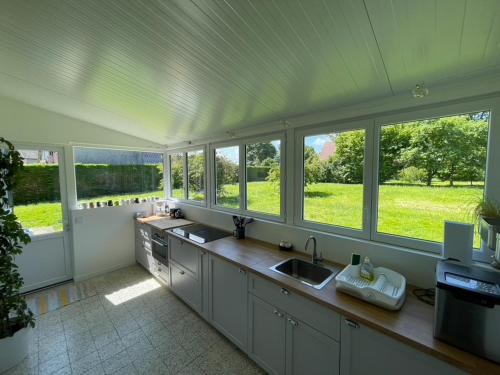 a large kitchen with windows and a counter with sinks at Maison de Campagne pour 6 personnes Baromesnil in Baromesnil