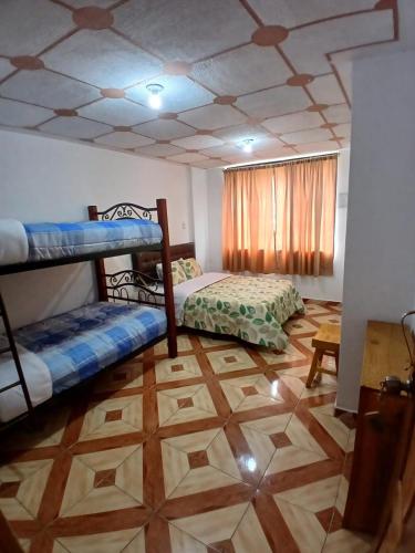 a room with two bunk beds and a wooden floor at Golden Bird in Mindo