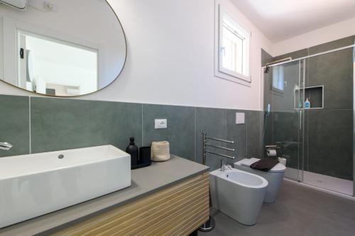 a bathroom with a sink and a toilet and a mirror at Appartamento Santa Maria Nuova in Reggio Emilia