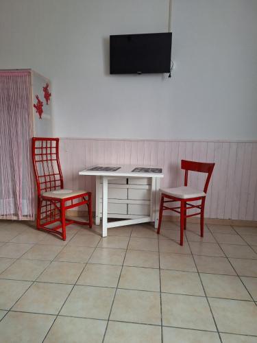 a room with two chairs and a desk and a tv at Tiny Torbiera in Val di Chy