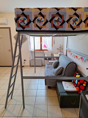 a loft bed in a living room with a couch at Tiny Torbiera in Val di Chy
