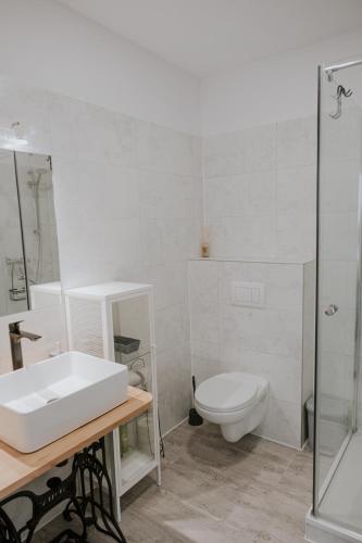 a white bathroom with a sink and a toilet at Kavárna a penzion Orava in Karviná