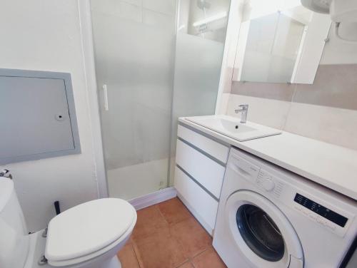 une salle de bain avec une machine à laver et un lavabo dans l'établissement Le studio des Garrigues - Climatisé, à Gréoux-les-Bains
