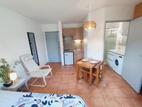 un salon avec une table et une cuisine dans l'établissement Le studio des Garrigues - Climatisé, à Gréoux-les-Bains