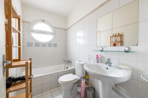 a white bathroom with a sink and a toilet at Home Up Enghien in Enghien-les-Bains