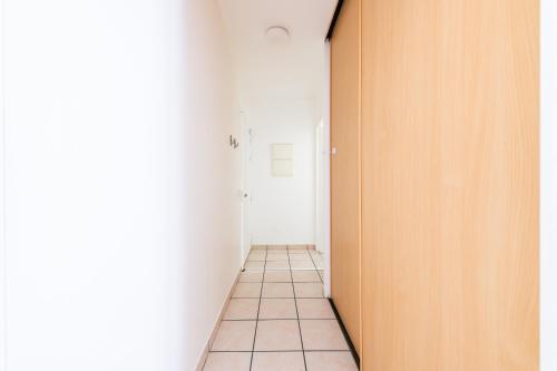a hallway with a door and a tile floor at Home Up Enghien in Enghien-les-Bains