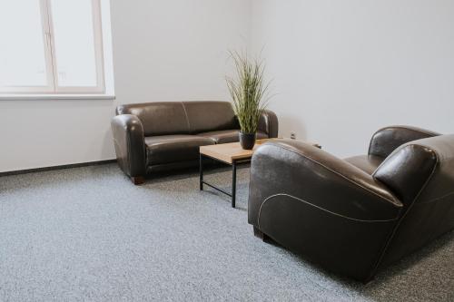 a living room with two couches and a table at Kavárna a penzion Orava in Karviná