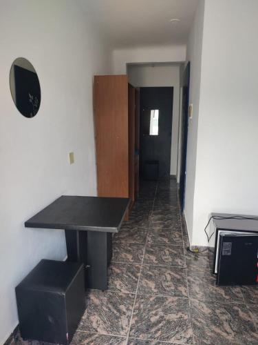 a room with a black table and a hallway at Pousada Styllus Miguel Pereira in Miguel Pereira