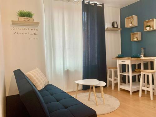 un salon avec un canapé bleu et une table dans l'établissement Le Petit Nid, à Longwy
