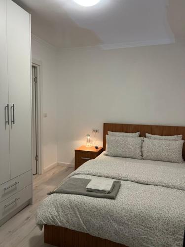 a bedroom with a large bed and a night stand at Apartament Ultracentral in Rădăuţi