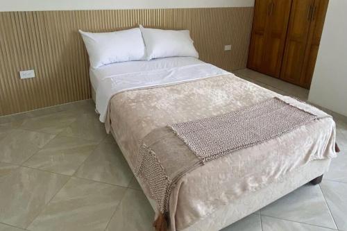 a bed with white sheets and pillows in a room at Apartamento de lujo en Mocoa in Mocoa