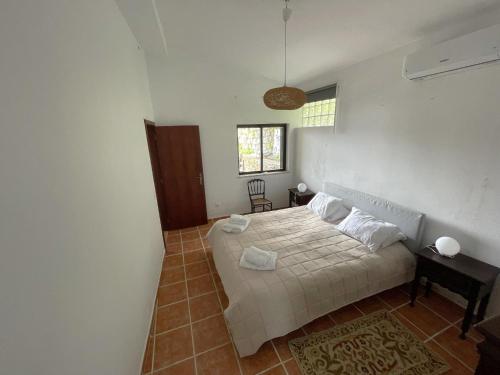 a bedroom with a bed and a table and a window at Casa da Foía in Monchique