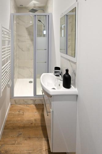 une salle de bain blanche avec un lavabo et une douche dans l'établissement La Pinta - Fécamp, à Fécamp