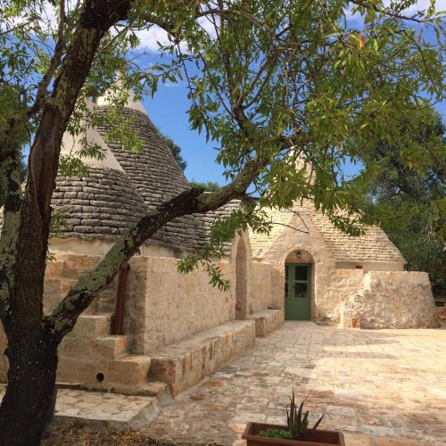 Una vista exterior de un edificio con una puerta verde. en Trullo Amato, en Ceglie Messapica