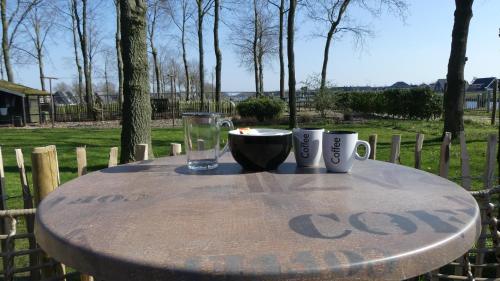 a table with a candle and two cups on it at B&B De SluisPod in Hoogeveen