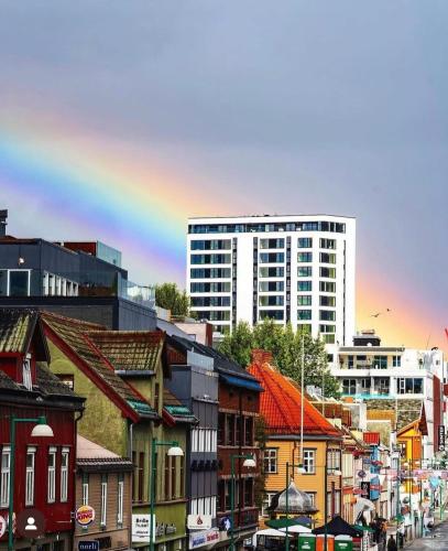 a city with buildings and a rainbow in the background at City center Panorama in Tromsø