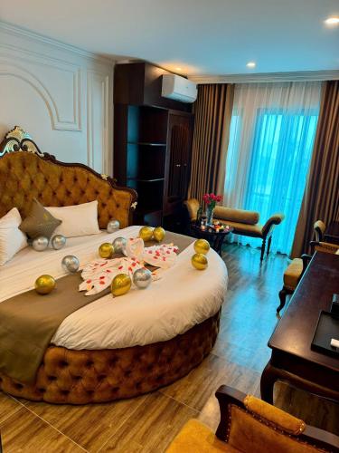 a hotel room with a large bed with fruit on it at Luxury Hanoi Hotel in Hanoi