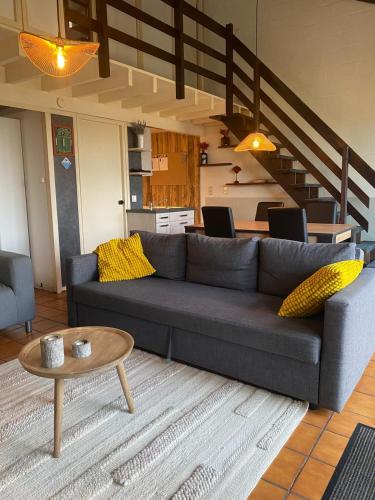 a living room with a couch and a table at Mon CoCoo in Stavelot