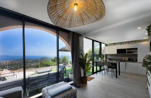 Il comprend une cuisine et un salon avec de grandes baies vitrées. dans l'établissement La Terrasse de Marie - superbe vue, terrasse, piscine, à Cavalaire-sur-Mer