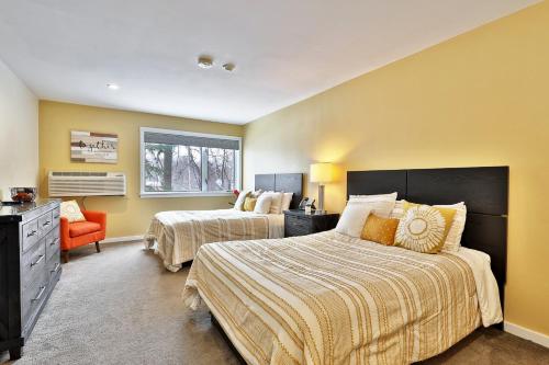 a bedroom with two beds and an orange chair at Hotel Style Condo Promising a Comfortable and Convenient Retreat right in the heart of Vermont ski country in Killington