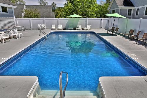 a large swimming pool with chairs and umbrellas at Hotel Style Condo Promising a Comfortable and Convenient Retreat right in the heart of Vermont ski country in Killington