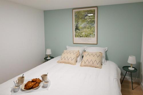 a white bed with a plate of food on it at La Niña - Parking Gratuit in Fécamp