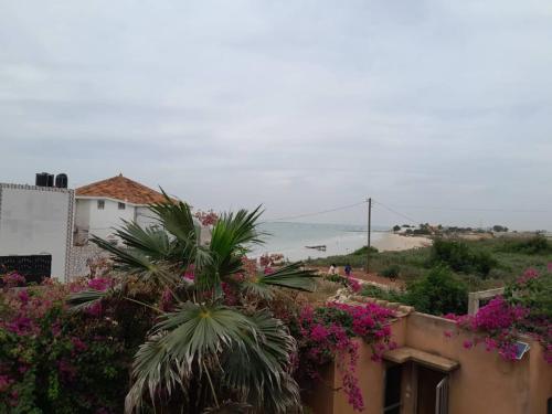 a view of the ocean from a building with flowers at Résidence Keur Fleurie in Toubab Dialaw