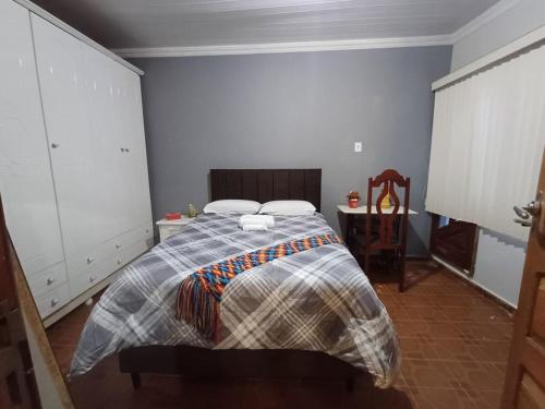 a bedroom with a bed and a table in it at Apê 02 - confortável e perto de tudo in Vitória da Conquista